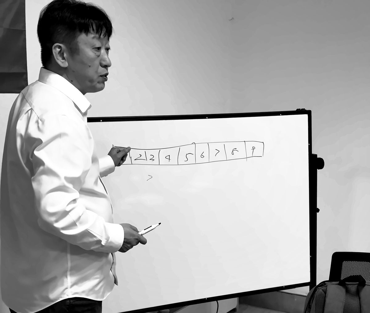 Weiping Ji explains a plan at a whiteboard