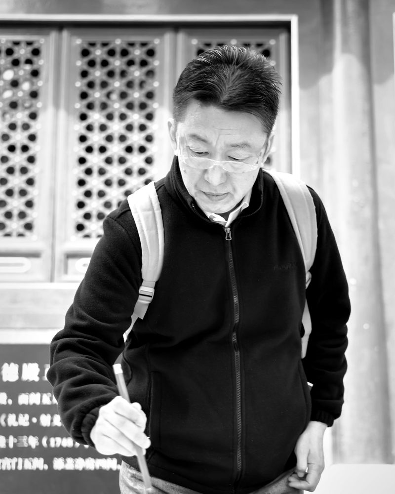 Weiping Ji writing with a brush